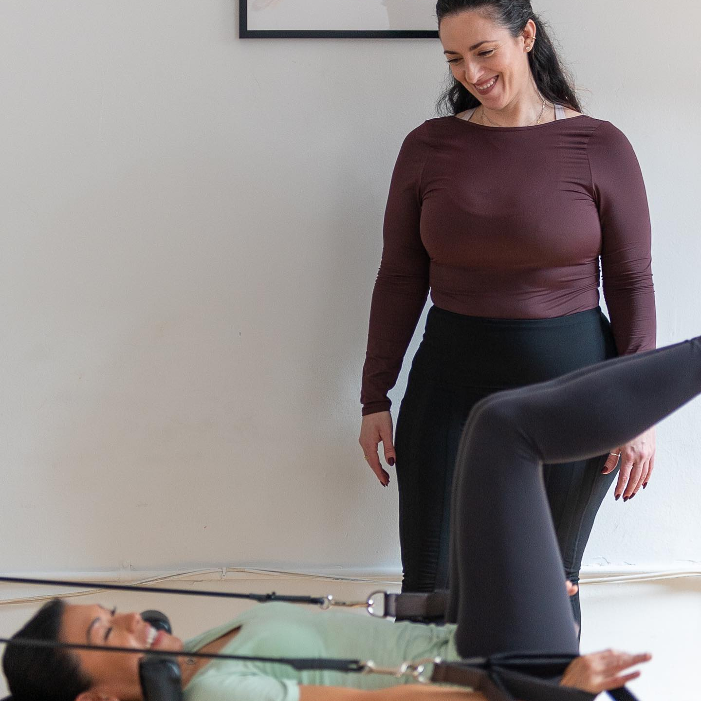Pilates instructor guiding a patient through a clinical Pilates Reformer exercise at ActiveCare Physical Therapy NYC in Midtown Manhattan.