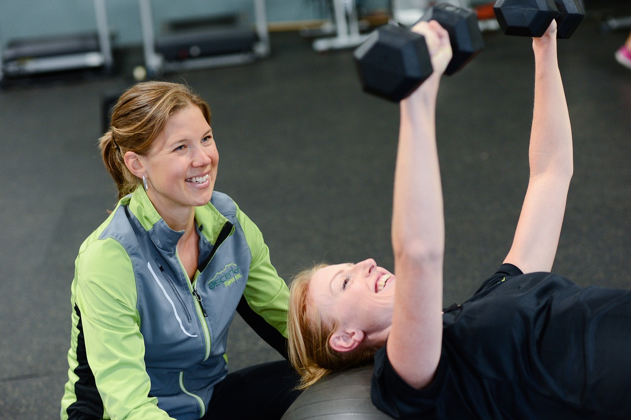 ActiveCare Physical Therapy NYC personal trainer guiding a client through a strength training session with dumbbells to improve fitness, mobility, and overall health.